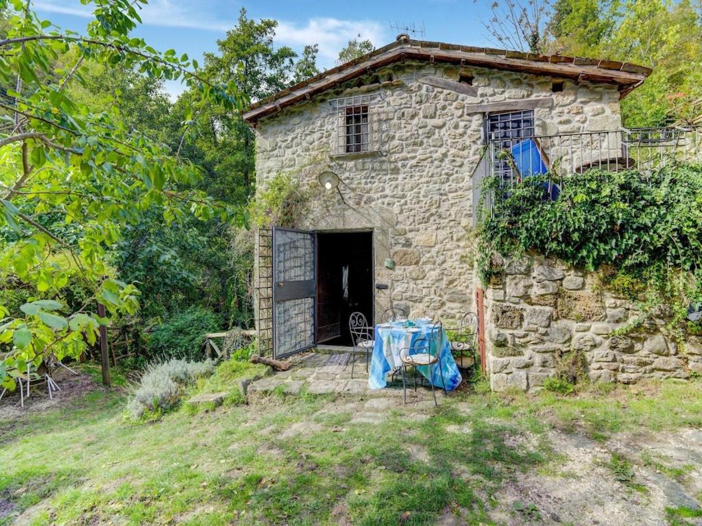 ein altes Steinhaus mit einem Tisch davor in der Unterkunft Belvilla by OYO Mulino in Piana di Forcella