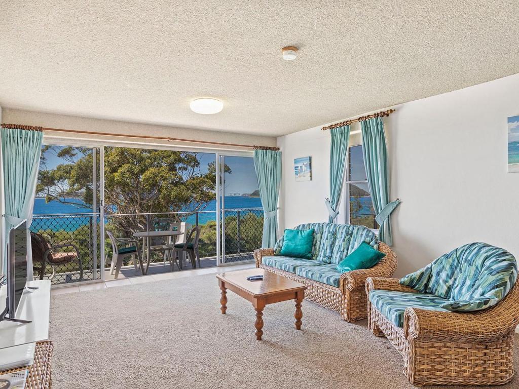 a living room with a couch and a table at Luskin Lodge Unit 10 29 Weatherly Close in Nelson Bay