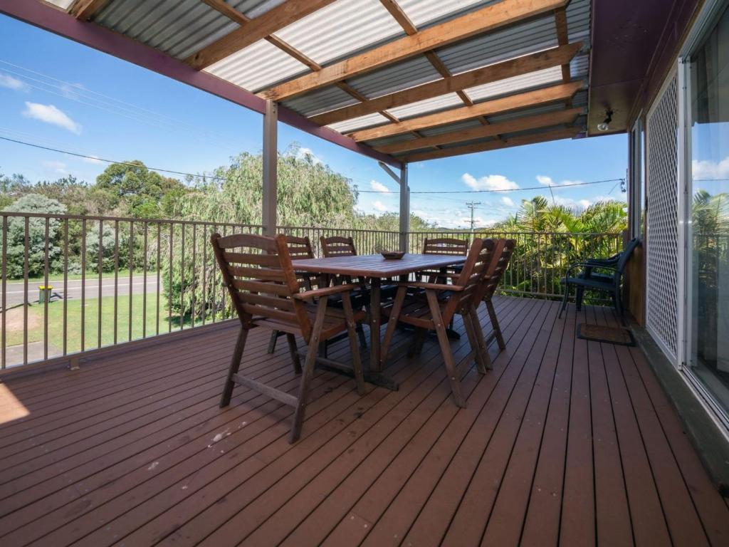 a patio with a table and chairs on a deck at Marine Drive 32 in Fingal Bay