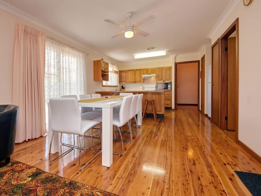 a kitchen and dining room with a table and chairs at Nelson Street 19 in Nelson Bay