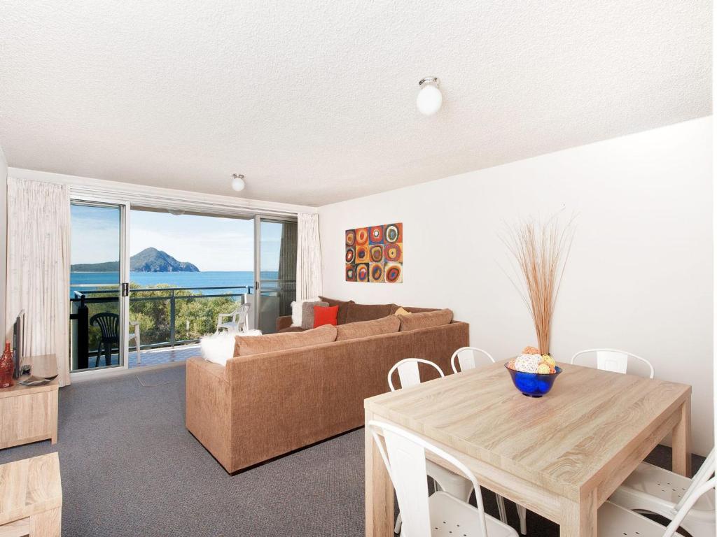 a living room with a couch and a table at Ocean Shores Unit 10 27 Weatherly Close in Nelson Bay