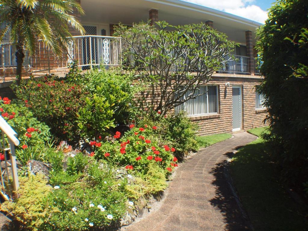a house with a garden of flowers in front of it at Pacific Drive 89 in Fingal Bay