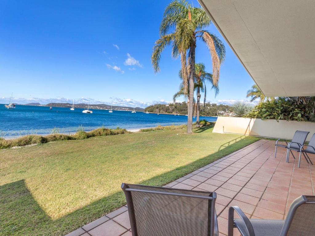 a patio with chairs and a view of the water at Panarea Soldiers Point Road Unit 1 197 in Salamander Bay