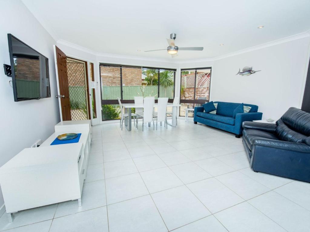 salon z kanapą i stołem w obiekcie Pet Friendly Tomaree Rd 142 Shoal Bay w mieście Shoal Bay