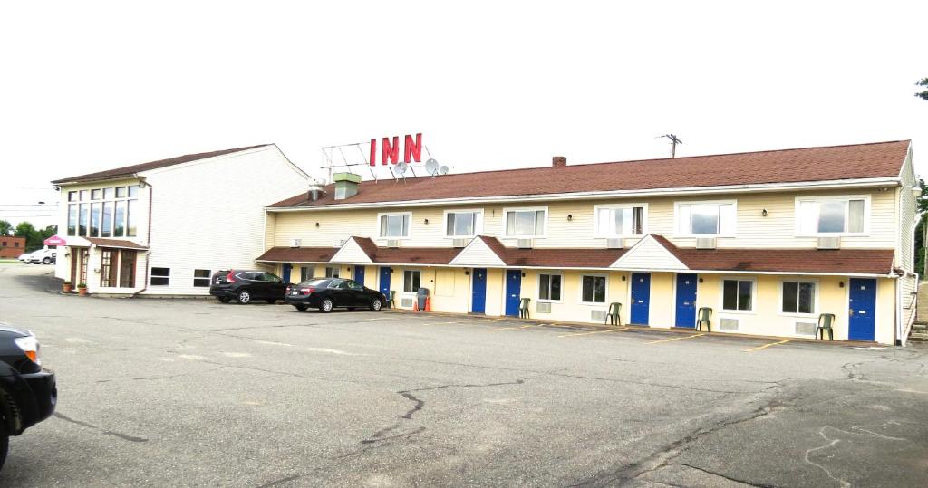 a large building with cars parked in front of it at Budget Host Airport Inn in Waterville