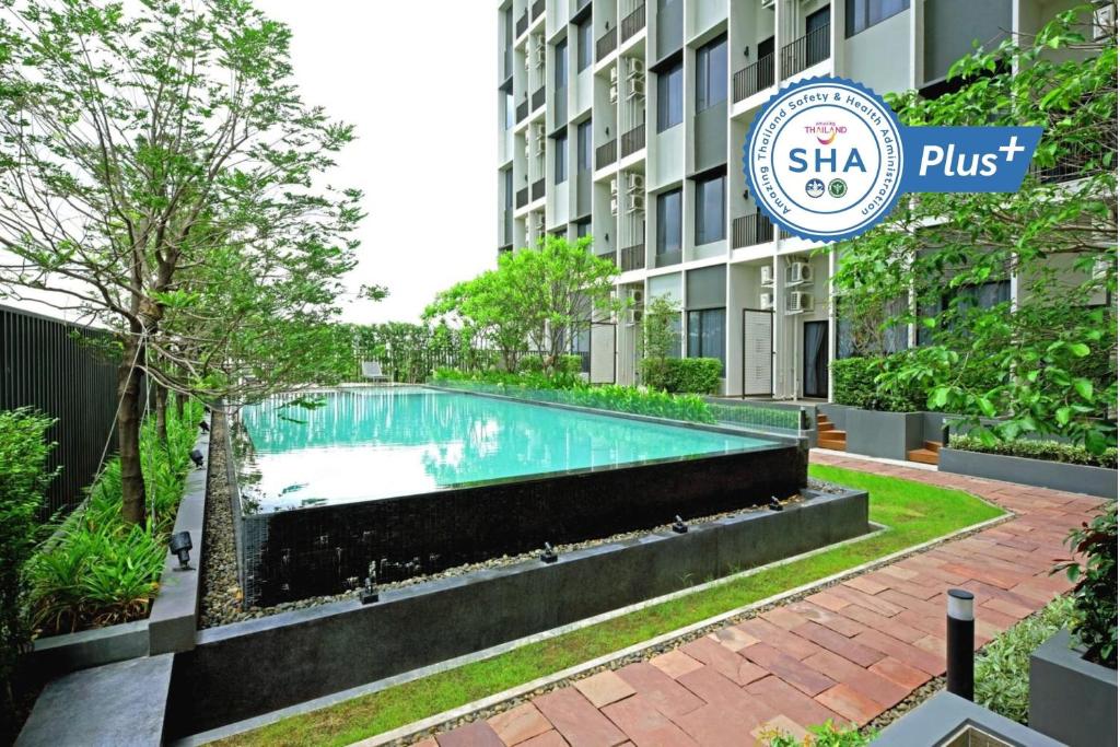 a swimming pool in front of a building at Q Box Hotel Bangkok Blossom SHA Plus in Bangkok