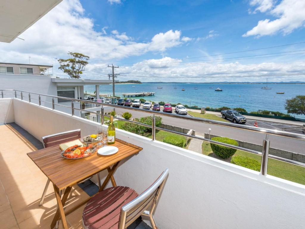 a balcony with a table and chairs and a view of the water at Del Rae Unit 8 25 Shoal Bay Road in Shoal Bay