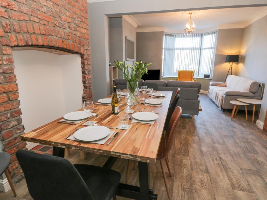 a dining room with a table and a brick wall at Hilderthorpe House in Bridlington