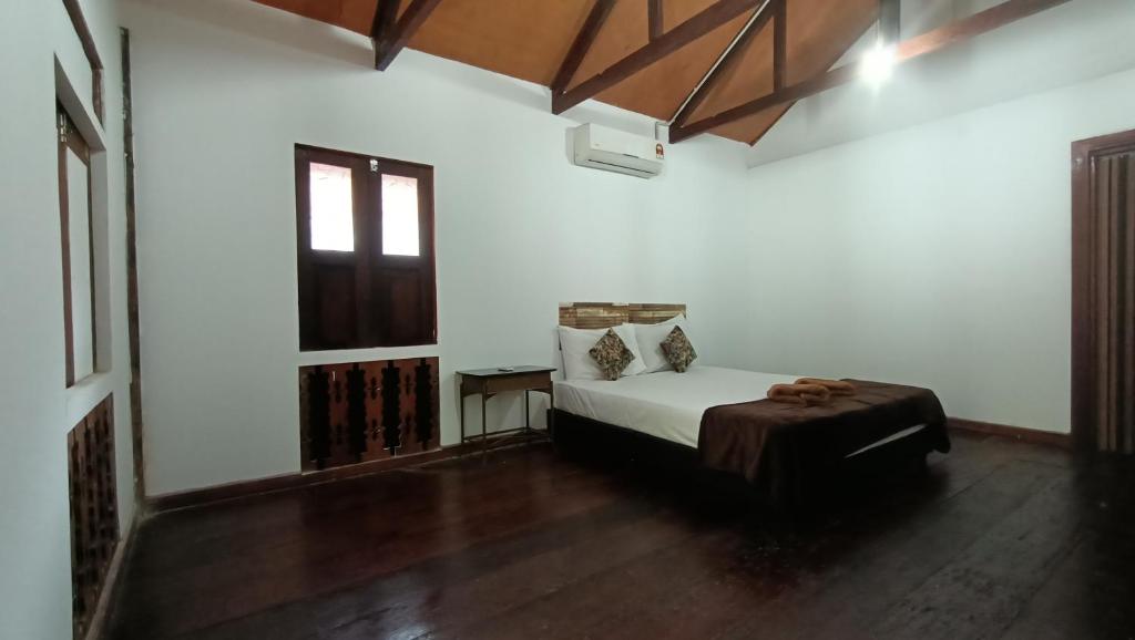 珍南海灘的住宿－Drym Valley Langkawi，一间带床的卧室,位于带窗户的房间内