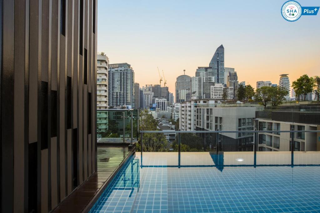 a swimming pool on the roof of a building with a city skyline at Adelphi Forty-Nine in Bangkok