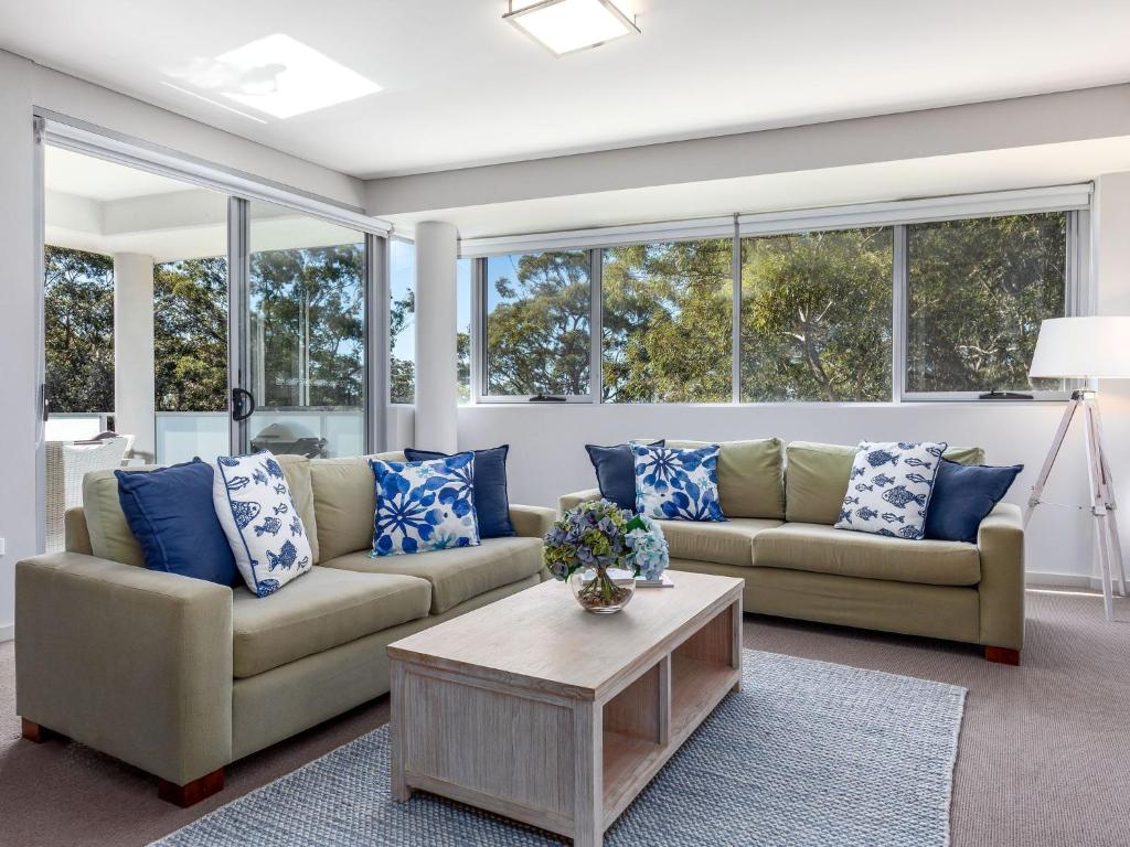 a living room with two couches and a coffee table at Aqua View by Jervis Bay Rentals in Huskisson