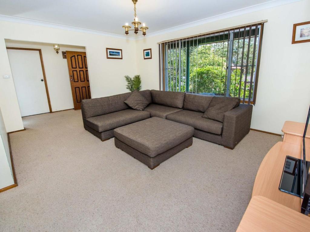 a living room with a couch and a window at Government Rd 63 Shoal Bay in Shoal Bay