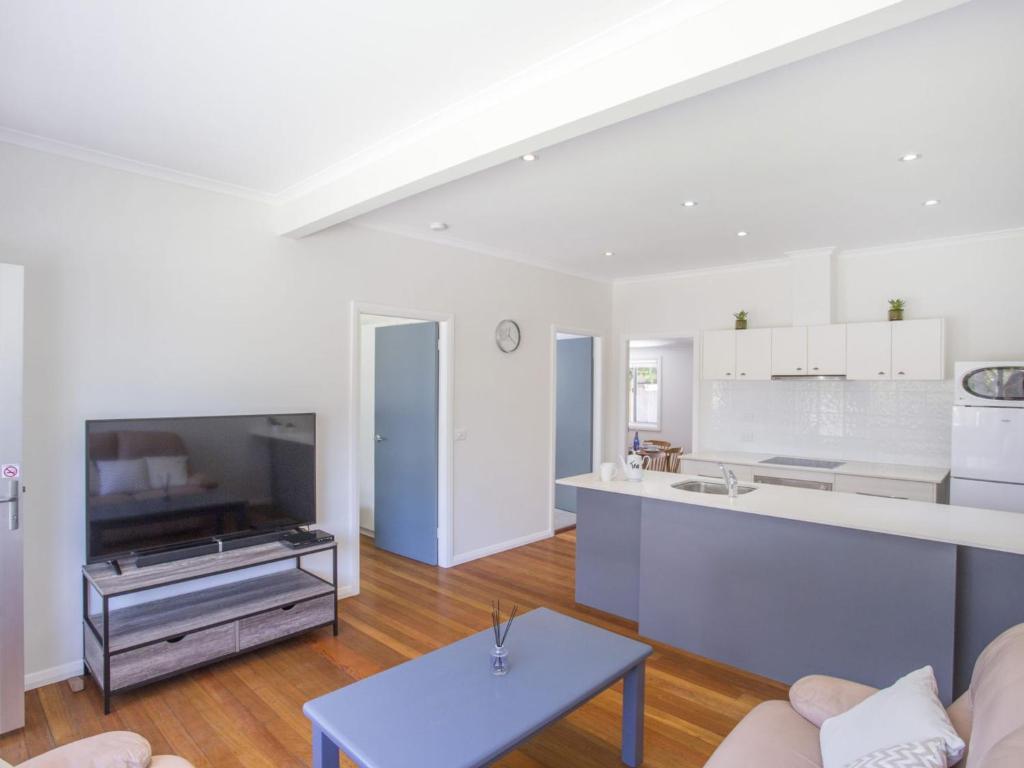 a kitchen and living room with a couch and a table at Harbour Breeze in Ulladulla