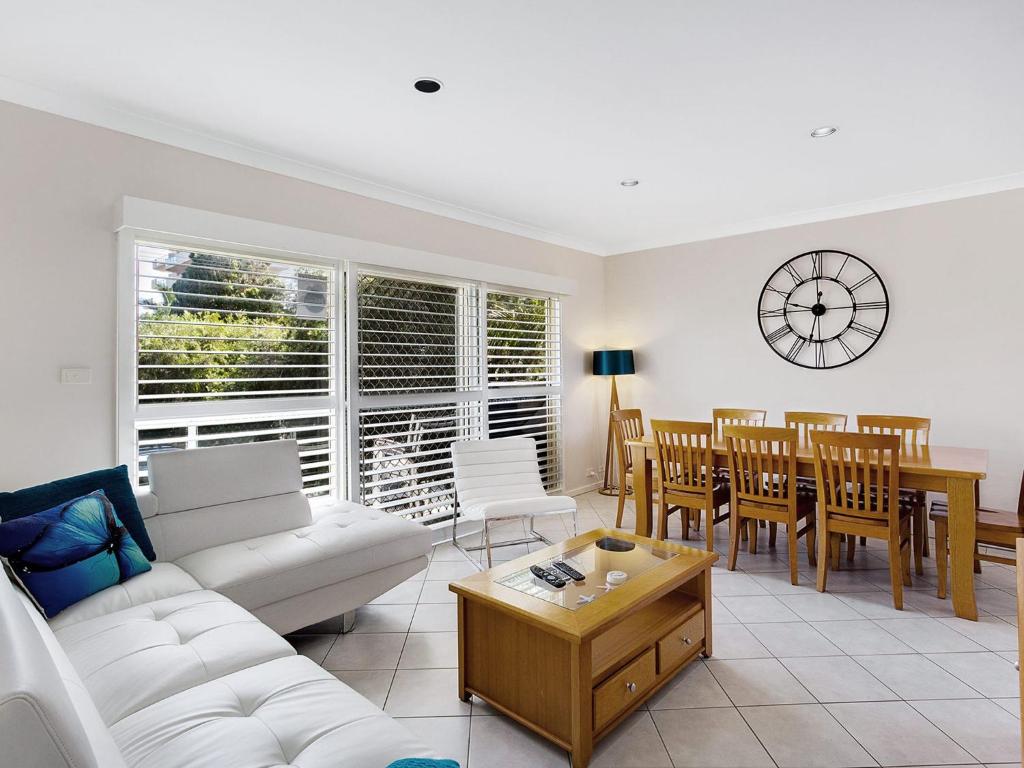 a living room with a white couch and a table at Sandy Shores 1 3 Messines Street in Shoal Bay