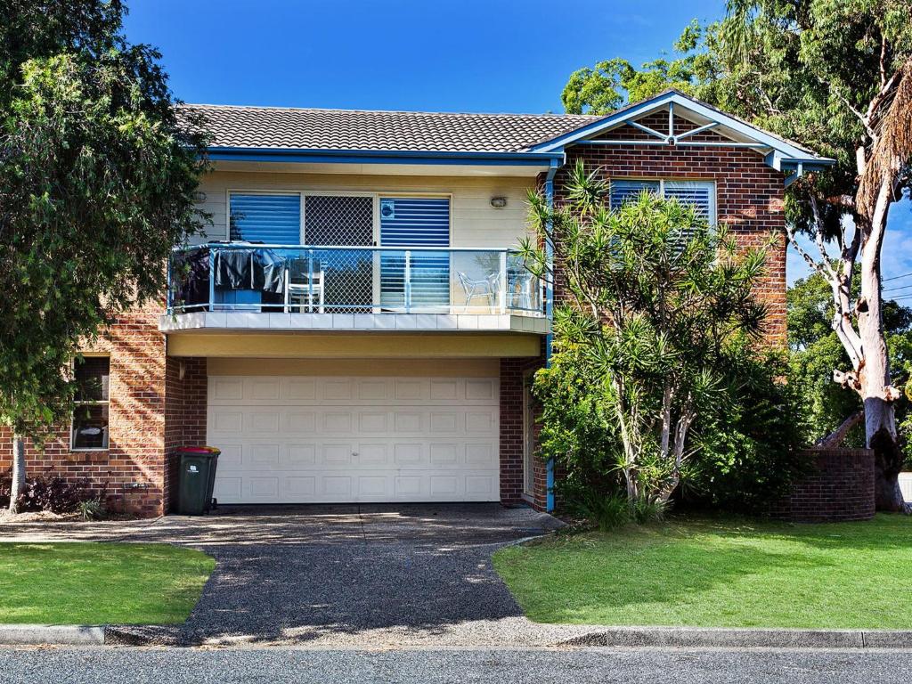 a brick house with a balcony and a porch at Sandy Shores 1 3 Messines Street in Shoal Bay