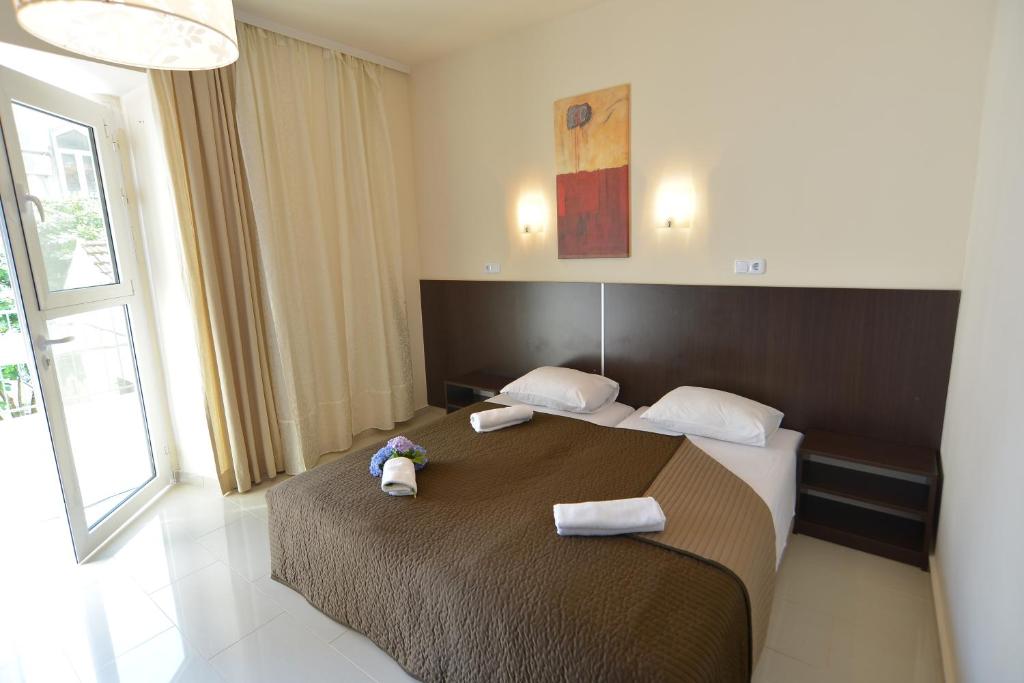 1 dormitorio con 2 camas con toallas y un animal de peluche en la cama en Solar Apartments, en Herceg-Novi