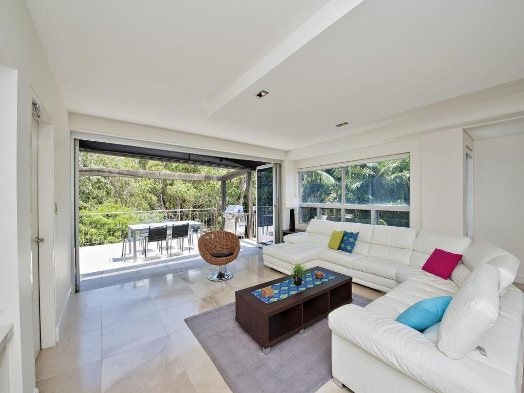 a living room with a white couch and a table at The Domain Unit 2 19 Voyager Close in Nelson Bay