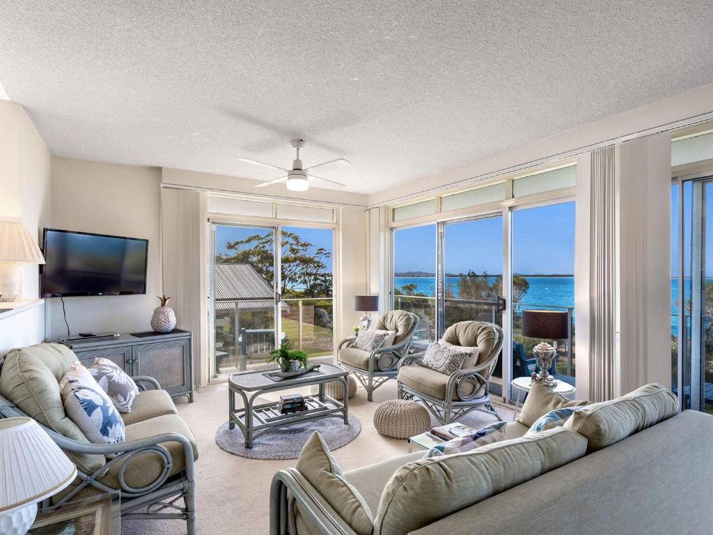 a living room with a couch and chairs and a television at The Helm 4 22 Voyager Close in Nelson Bay