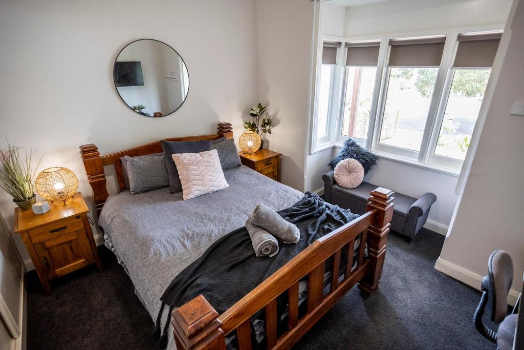 una camera con un grande letto e uno specchio di Cabo’s On Currajong Warm, Cosy and Welcoming a Parkes