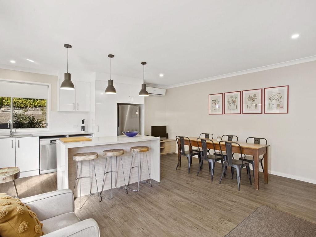 uma cozinha e sala de estar com mesa e cadeiras em Stockton Street 1 72 em Nelson Bay