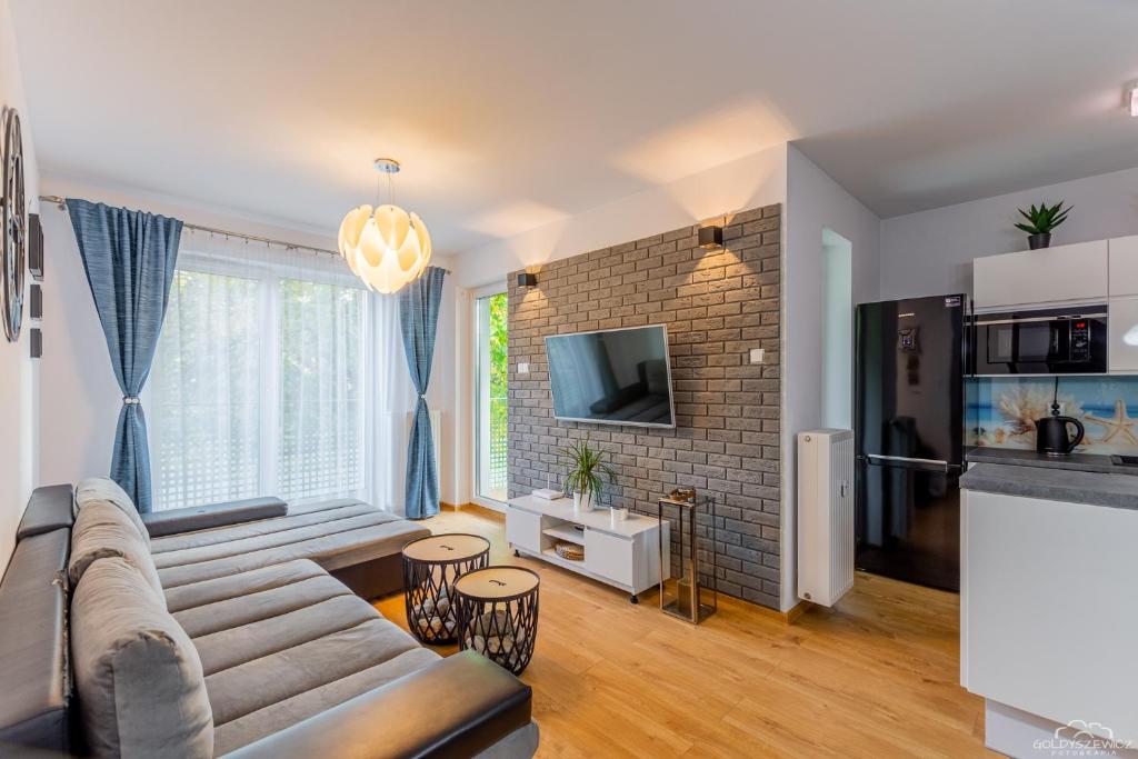 a living room with a couch and a tv at Apartament Solna 208 Kołobrzeg in Kołobrzeg