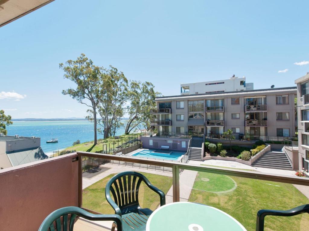 a balcony with chairs and a view of the ocean at The Poplars Unit 31 34 Magnus Street in Nelson Bay