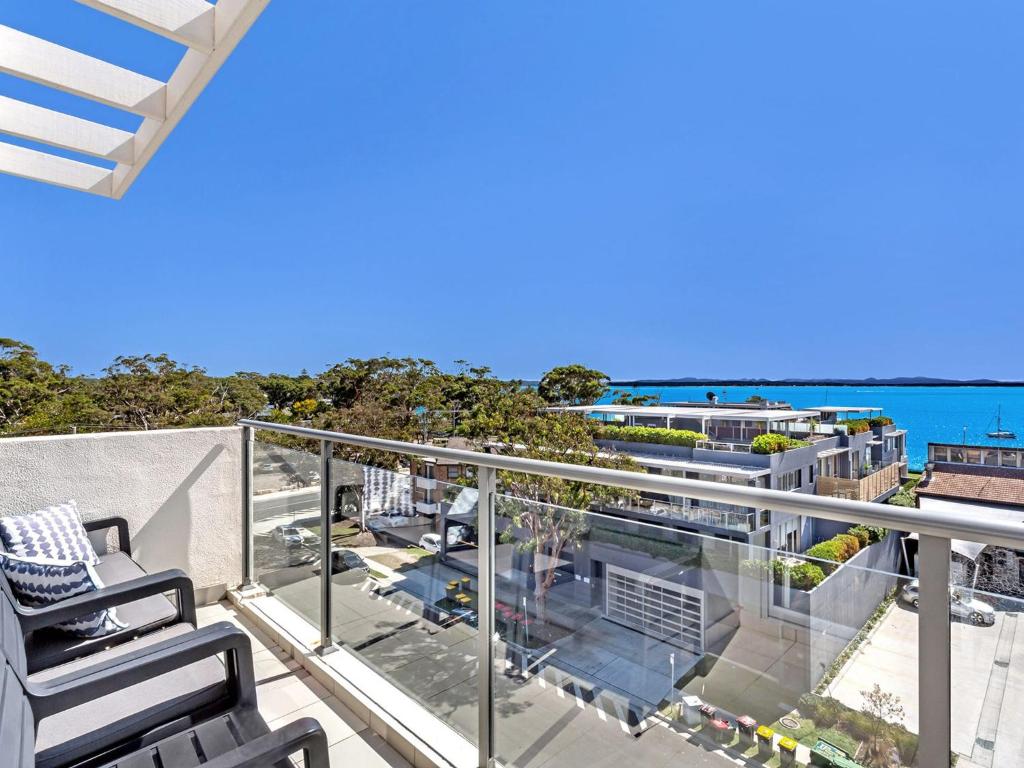 a balcony with chairs and a view of the ocean at The Shoal Apartments, Unit 504/4-8 Bullecourt Street in Shoal Bay
