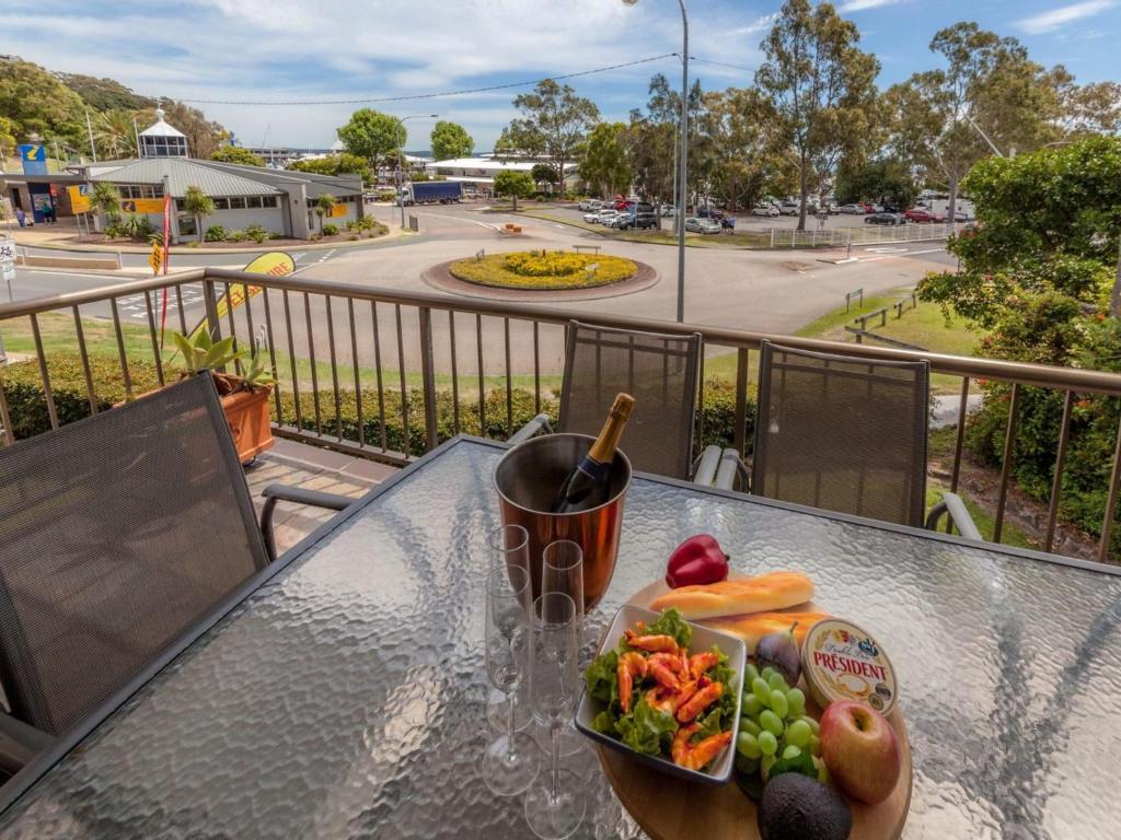 a plate of food on a glass table on a balcony at Tradewinds Unit 3 110 Victoria Parade in Nelson Bay