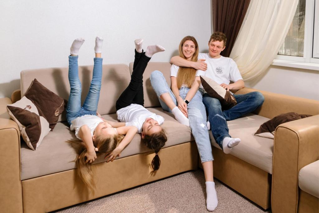 a group of four people laying on a couch at Rider Hotel in Miass