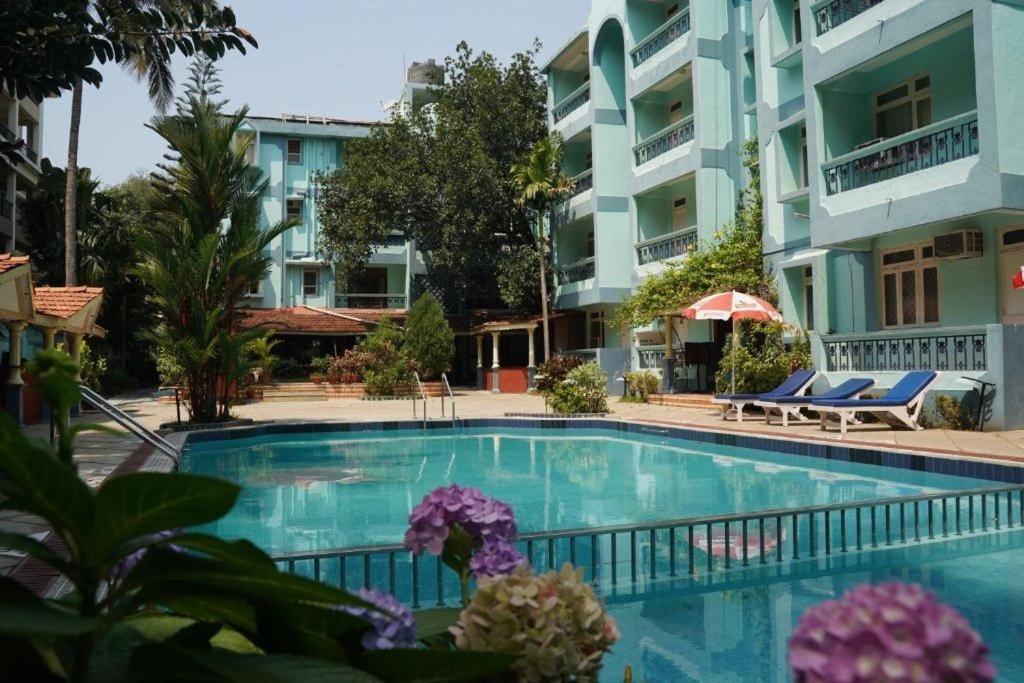 a swimming pool in front of a building at Osborne Holiday Resorts in Calangute