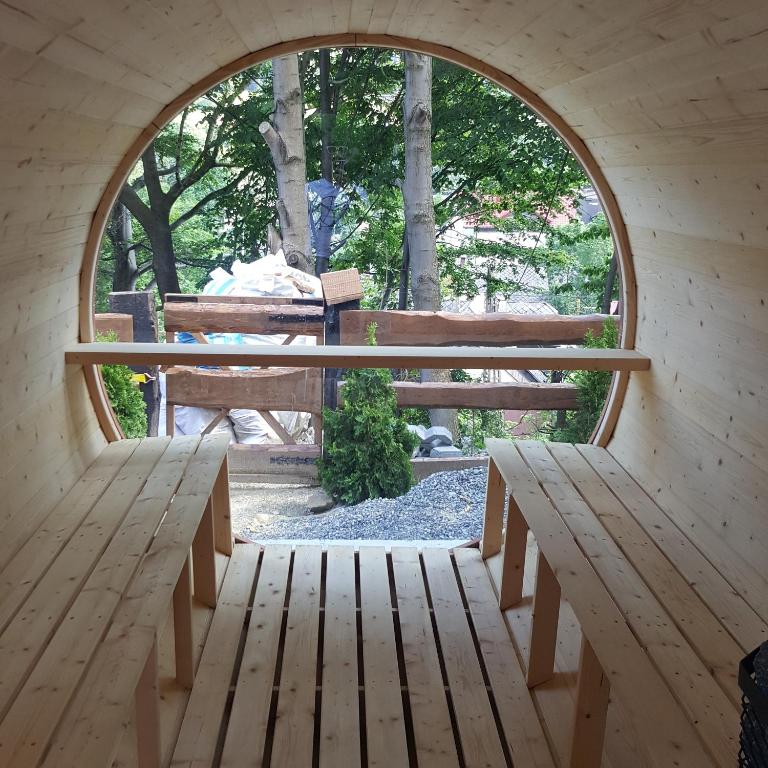 an arched window in a wooden room with benches at Pensjonat Gościniec Szczyrk , z sauną i jacuzzi in Szczyrk
