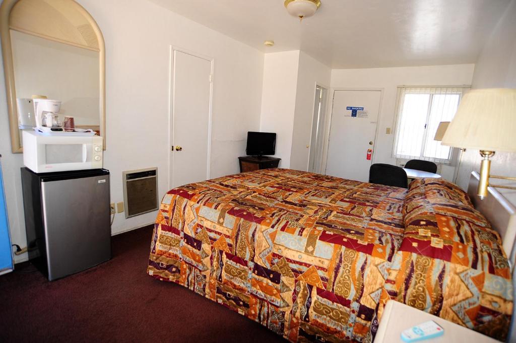 a hotel room with a bed with a colorful bedspread at Safari Motor Inn - Joshua Tree in Joshua Tree