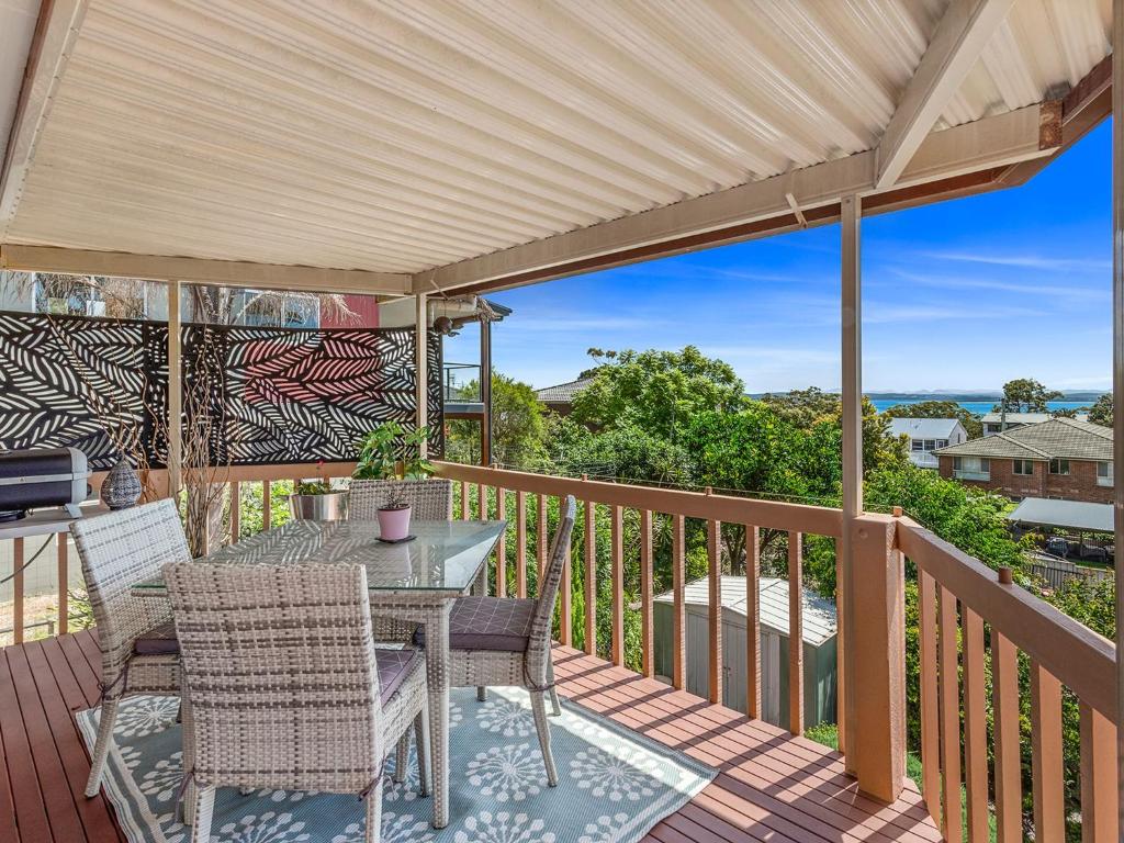 a patio with a table and chairs on a deck at Wahgunyah Road 50 in Nelson Bay