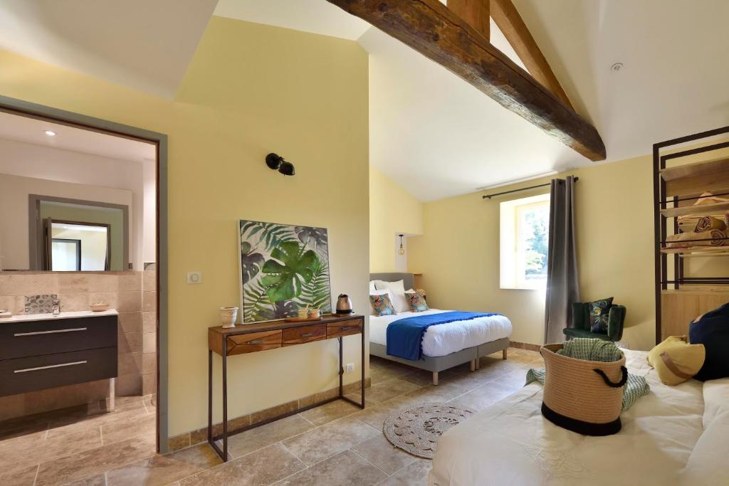 a bedroom with a bed and a bathroom with a sink at Les Jardins de Falguière in Saint-Jean-du-Gard