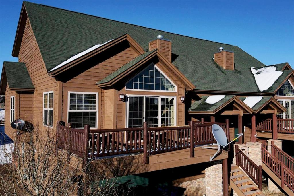 a house with a wooden deck with a roof at 67 Fireweed 27A by Stay Winter Park in Tabernash
