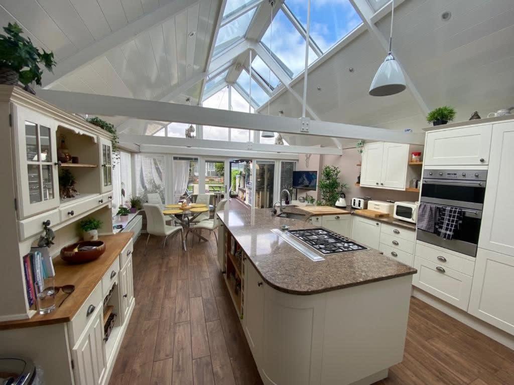 サウサンプトンにあるWinsor Croftの白いキャビネットと大きな窓付きの広いキッチンが備わります。