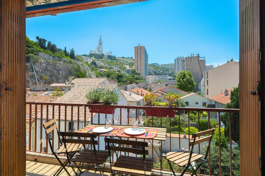 een terras met een tafel en stoelen op een balkon bij Un balcon sur Notre Dame in Marseille