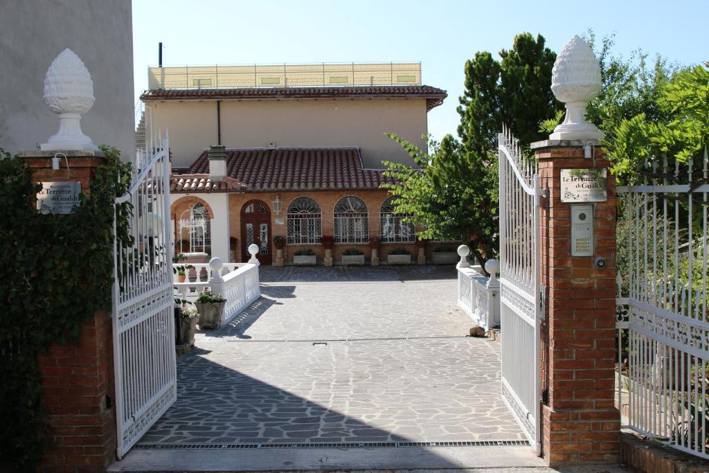 an entrance to a house with a white fence at Residenza Le Terrazze di Gualdo Rent Rooms in Gualdo Tadino