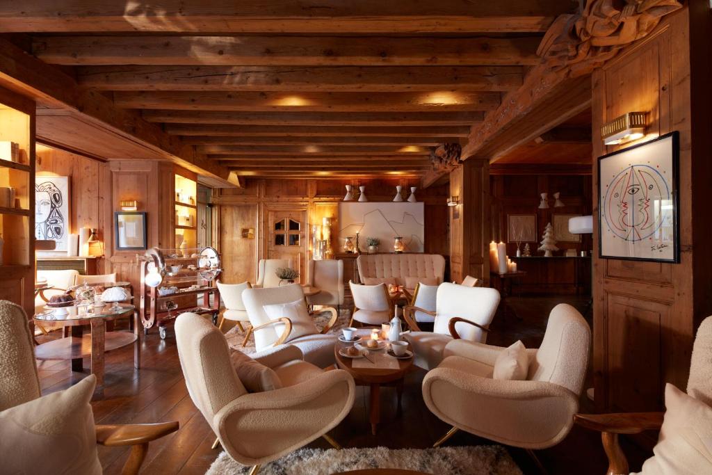 uma sala de estar com cadeiras e mesas brancas em Hotel Mont Blanc Megève em Megève