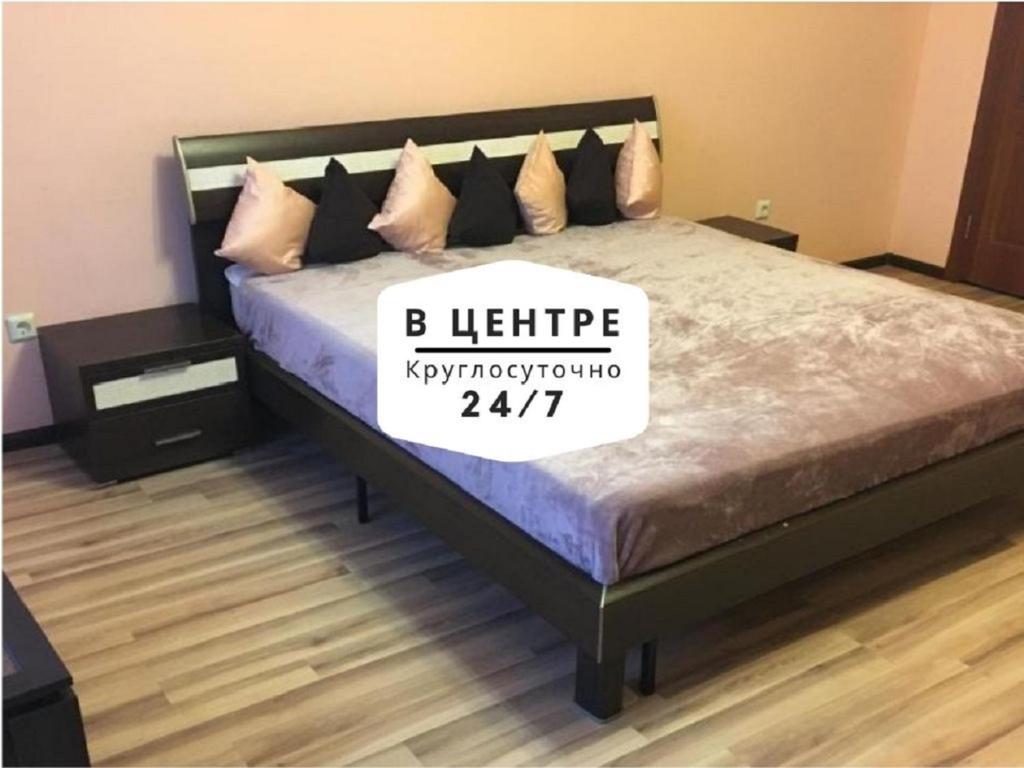 Un dormitorio con una cama con un cartel. en Апартаменты Welcome Home на Циолковского 7к2 en Tyumen