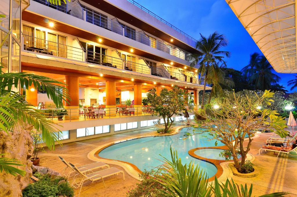 a hotel with a swimming pool in front of a building at Samui First House Hotel in Chaweng