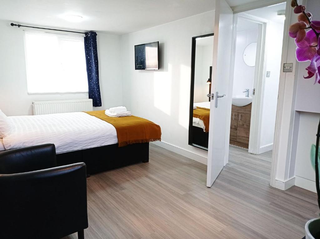 een hotelkamer met een bed en een spiegel bij Mill Studio A - Self contained one bed studio flat in Oxford