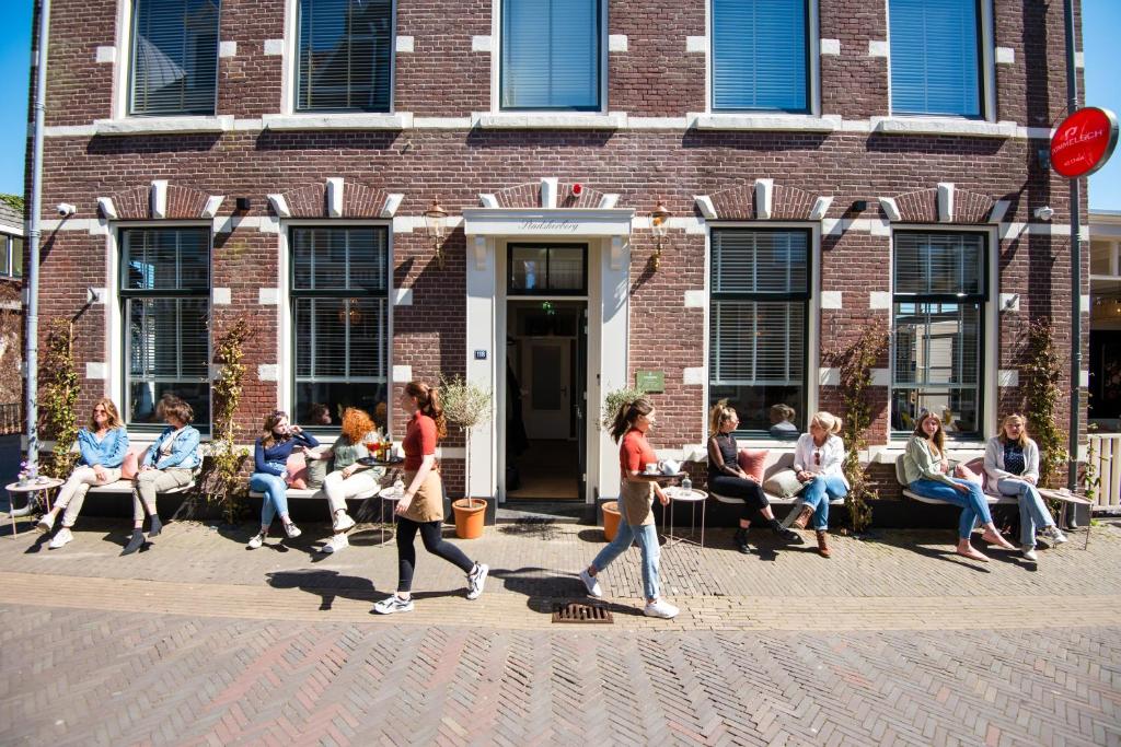 um grupo de pessoas andando em frente a um edifício de tijolos em Boutique Hotel - de Stadsherberg Alphen em Alphen aan den Rijn