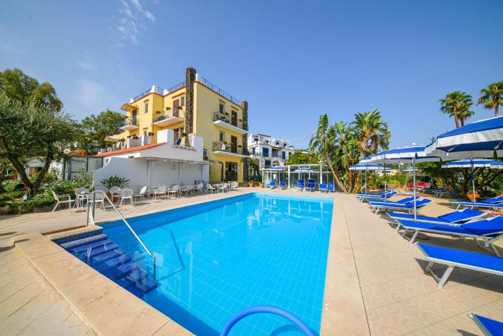 uma piscina com cadeiras e guarda-sóis num resort em Hotel Terme Principe em Ischia