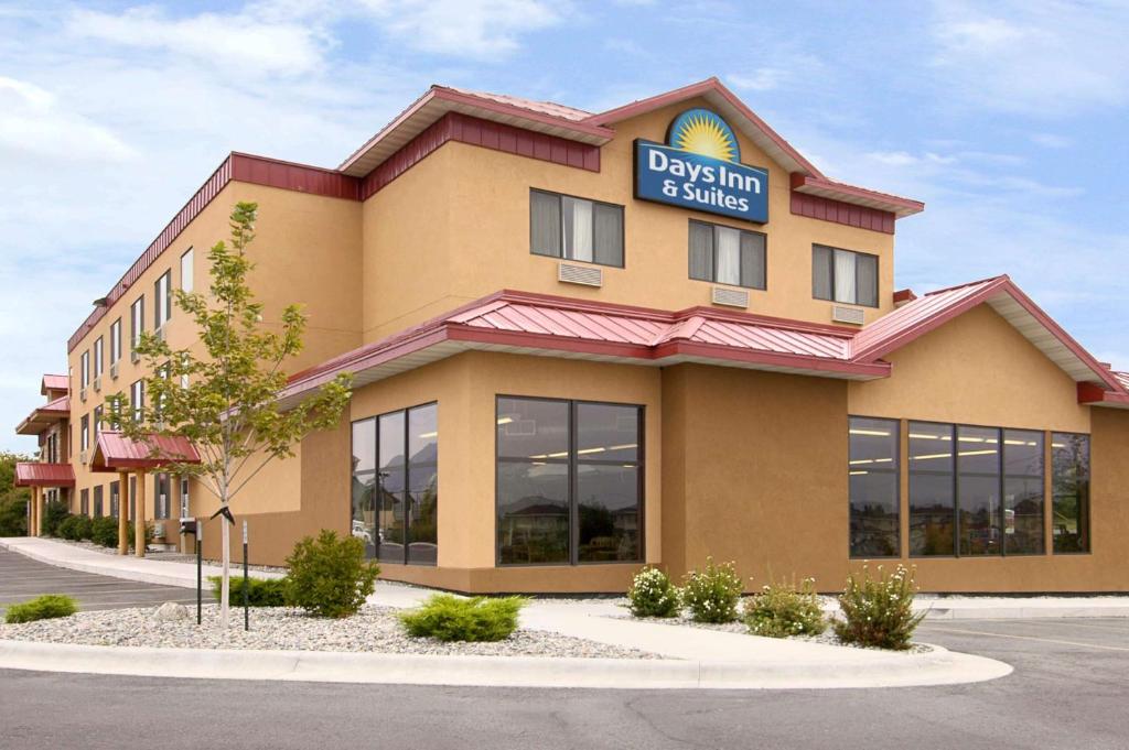 a dogs inn suites building with a sign on it at Days Inn & Suites by Wyndham Bozeman in Bozeman
