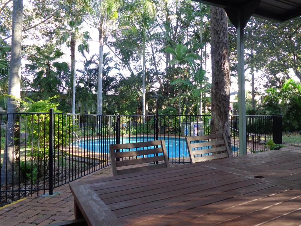 two benches sitting on a deck next to a pool at Forest Lodge Apartments in Brisbane