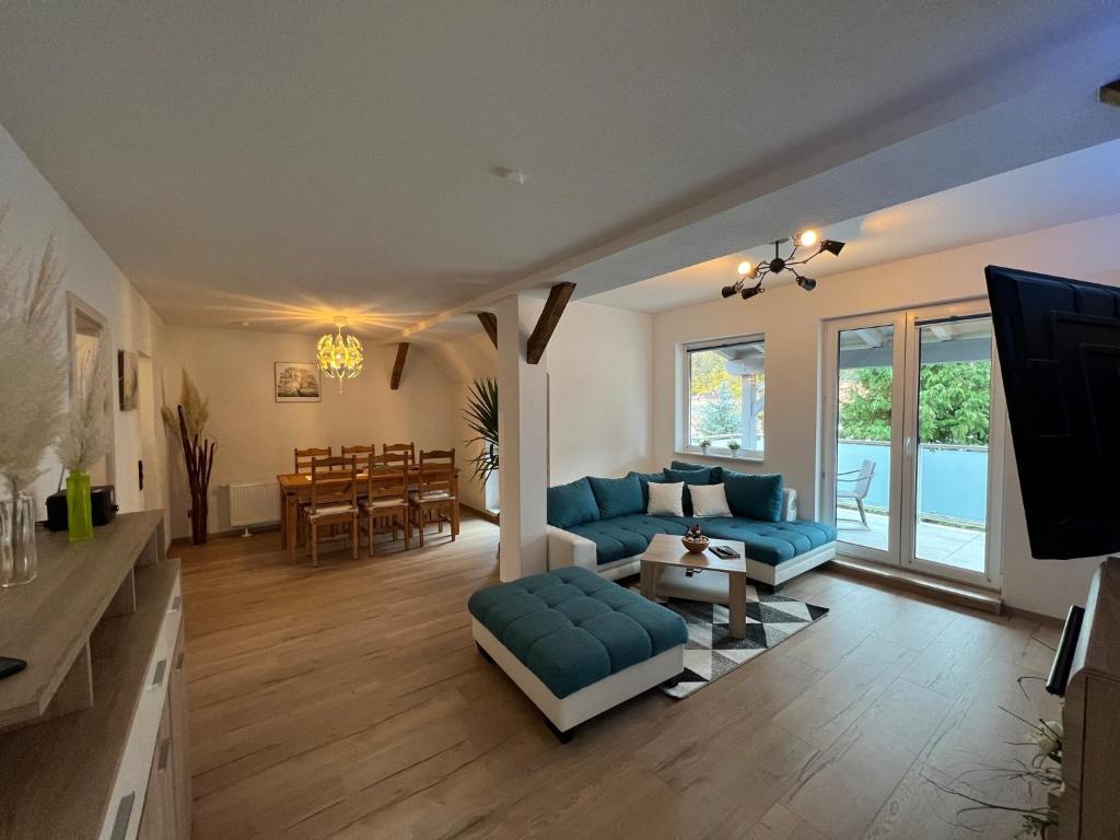 a living room with blue couches and a television at Ferienwohnung Familie Büchel in Zella-Mehlis