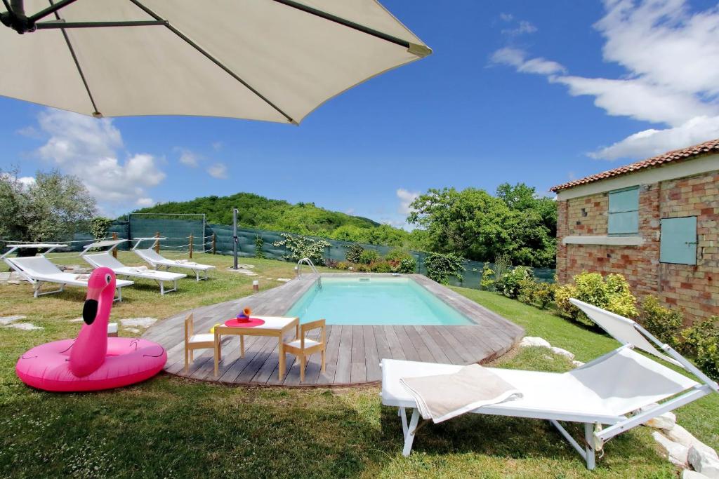 una piscina con mesa, sillas y sombrilla en Le Rondinelle en Trivio