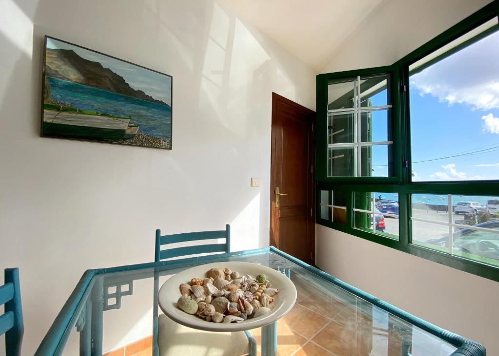 a dining room with a bowl of rocks on a glass table at Casa Bela in Arrieta