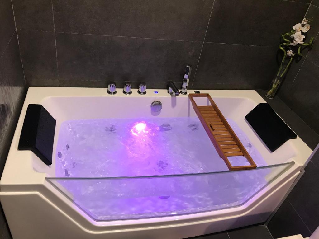 een wit bad met een paarse rand bij Suite Vitbanus in Marbella